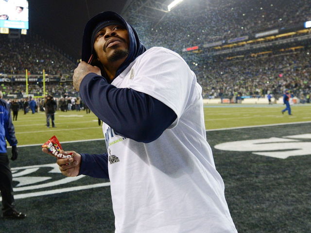 NFL Star Marshawn Lynch Dives Into A Pile Of Signature Skittles