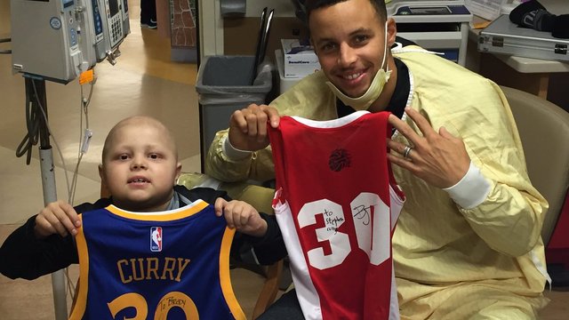 Curry and young fan with cancer swap jerseys, bracelets