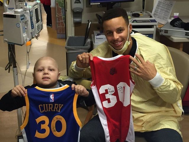 Curry and young fan with cancer swap jerseys, bracelets