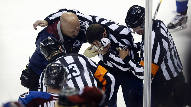 Watch: Linesman leaves game after taking puck to face