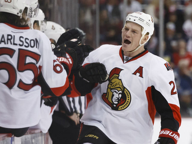 Teammates congratulate Chris Neil on reaching 1,000 NHL games
