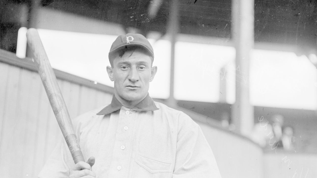UNITED STATES - CIRCA 1903: Half-length portrait of Hall of Famer Honus Wagner (also known as John Peter or The Flying Dutchman), player for the Pittsburgh Pirates, National League baseball team, standing on field near grandstand at West Side Grounds, Chicago, 1903. From the Chicago Daily News collection. (Photo by Chicago History Museum/Getty Images)