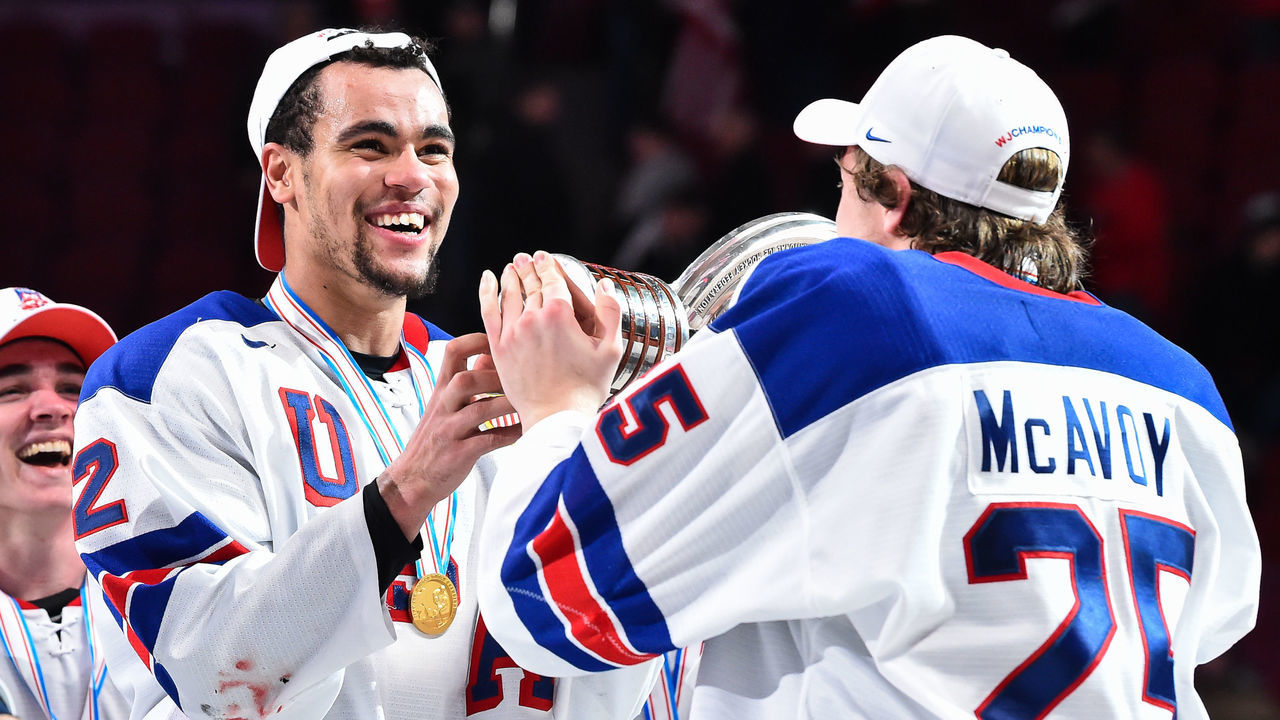 MONTREAL, QC - JANUARY 05: Charlie McAvoy #25 hands over the IIHF trophy to teammate Jordan Greenway #12 of Team United States during the 2017 IIHF World Junior Championship gold medal game against Team Canada at the Bell Centre on January 5, 2017 in Montreal, Quebec, Canada. Team United States defeated Team Canada 5-4 in a shootout and win the gold medal round. (Photo by Minas Panagiotakis/Getty Images)
