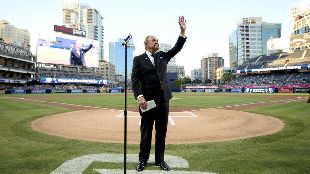 SAN DIEGO, CALIFORNIA - SEPTEMBER 29: San Diego Padres announcer Dick Enberg waves to the crowd during a ceremony held before a baseball game between the San Diego Padres and the Los Angeles Dodgers at PETCO Park on September 29, 2016 in San Diego, California. The Padres held the pre-game ceremony to honor Enberg's last home game as the team's primary play-by-play man for television broadcasts.