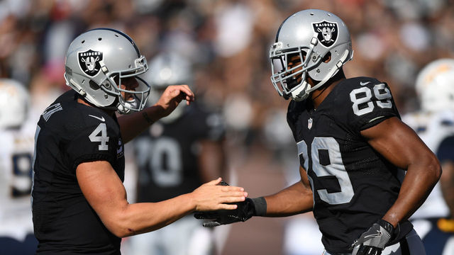 OAKLAND, CA - OCTOBER 09: Derek Carr #4 of the Oakland Raiders celebrates with Amari Cooper #89 after a scoring on a two-point conversion against the San Diego Chargers during their NFL game at Oakland-Alameda County Coliseum on October 9, 2016 in Oakland, California.