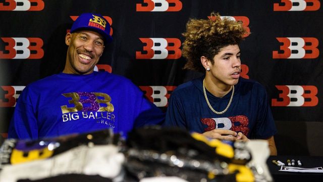 LaVar Ball (L), father of basketball player LiAngelo Ball and the owner of the Big Baller brand, sits with his other son LaMelo Ball during a promotional event in Hong Kong on November 14, 2017. UCLA players LiAngelo Ball -- the younger brother of Los Angeles Lakers rookie star Lonzo Ball -- and teammates Cody Riley and Jalen Hill were arrested on November 7 in Hangzhou ahead of their regular-season-opening game against Georgia Tech in nearby Shanghai this past weekend. ESPN reported that they were nabbed on suspicion of stealing from a Louis Vuitton store and later freed on bail but ordered to remain in Hangzhou. / AFP PHOTO / Anthony WALLACE