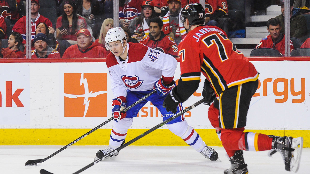 CALGARY, AB - DECEMBER 22: Byron Froese #42 of the Montreal Canadiens skates with the puck against Mark Jankowski #77 of the Calgary Flames during an NHL game at Scotiabank Saddledome on December 22, 2017 in Calgary, Alberta, Canada.