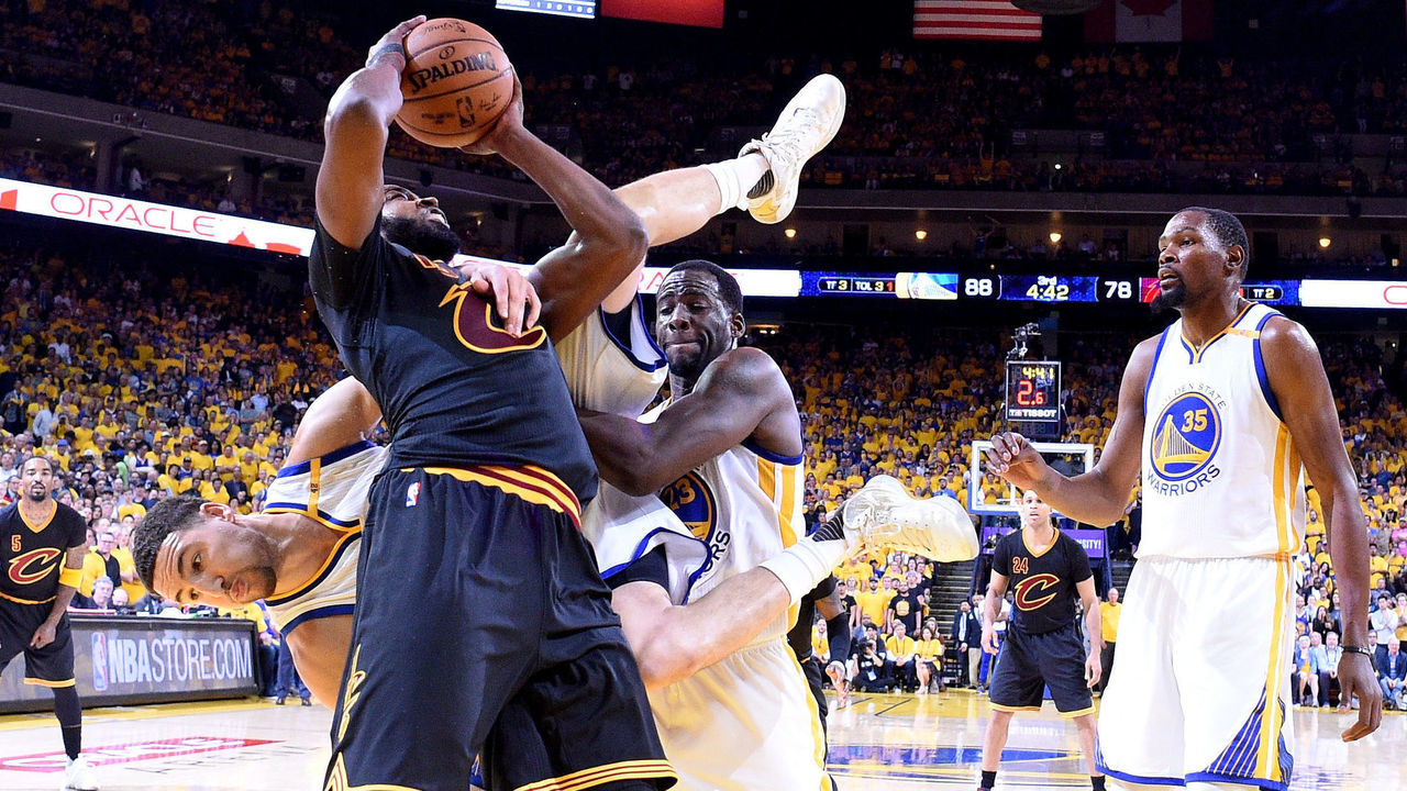 OAKLAND, CA - JUNE 12: Klay Thompson #11 of the Golden State Warriors is upended between Draymond Green #23 and Tristan Thompson #13 of the Cleveland Cavaliers in Game 5 of the 2017 NBA Finals at ORACLE Arena on June 12, 2017 in Oakland, California.