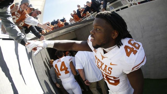 WACO, TX - OCTOBER 28: Malik Jefferson #46 of the Texas Longhorns celebrates with a fan following Texas' 38-7 win over the Baylor Bears at McLane Stadium on October 28, 2017 in Waco, Texas.