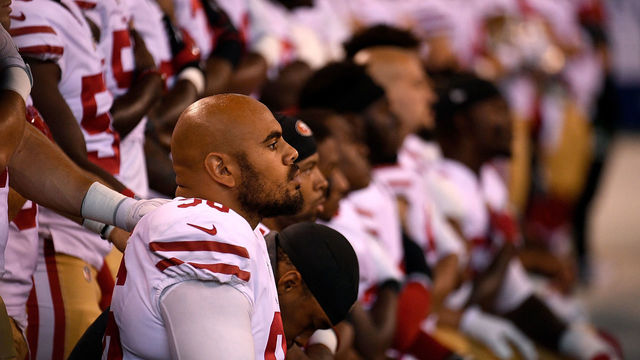 INDIANAPOLIS, IN - OCTOBER 08: Xavier Cooper #96 of the San Francisco 49ers and other members of the team kneel during the National Anthem before the game against the Indianapolis Colts at Lucas Oil Stadium on October 8, 2017 in Indianapolis, Indiana.