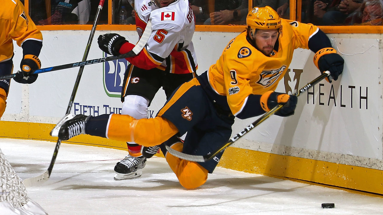 NASHVILLE, TN - OCTOBER 24: Mark Giordano #5 of the Calgary Flames trips Filip Forsberg #9 of the Nashville Predators during the first period at Bridgestone Arena on October 24, 2017 in Nashville, Tennessee.