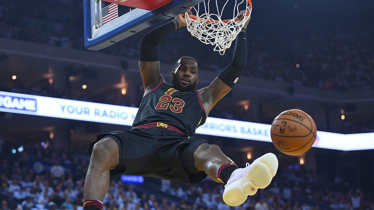 OAKLAND, CA - DECEMBER 25: LeBron James #23 of the Cleveland Cavaliers hangs onto the rim after a slam dunk against the Golden State Warriors during an NBA basketball game at ORACLE Arena on December 25, 2017 in Oakland, California.