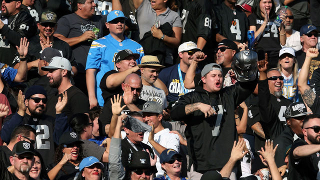 CARSON, CA - DECEMBER 31: A Los Angeles Chargers fan is seen surrounded by Oakland Raiders fans during the first half of the game at StubHub Center on December 31, 2017 in Carson, California.