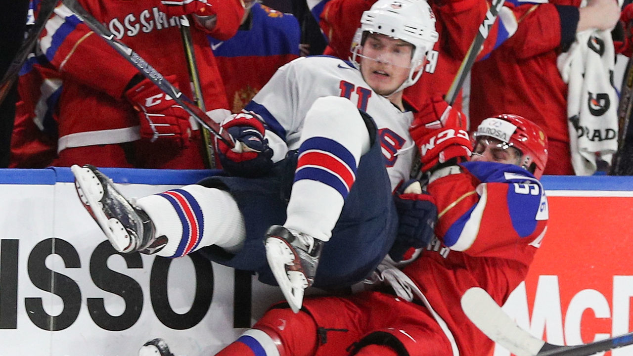 BUFFALO, NY - JANUARY 02: Ryan Lindgren #5 of United States takes a big hit from Andrei Altybarmakyan #16 of Russia during the second period of play in the Quarterfinal IIHF World Junior Championship game at the KeyBank Center on January 2, 2018 in Buffalo, New York.