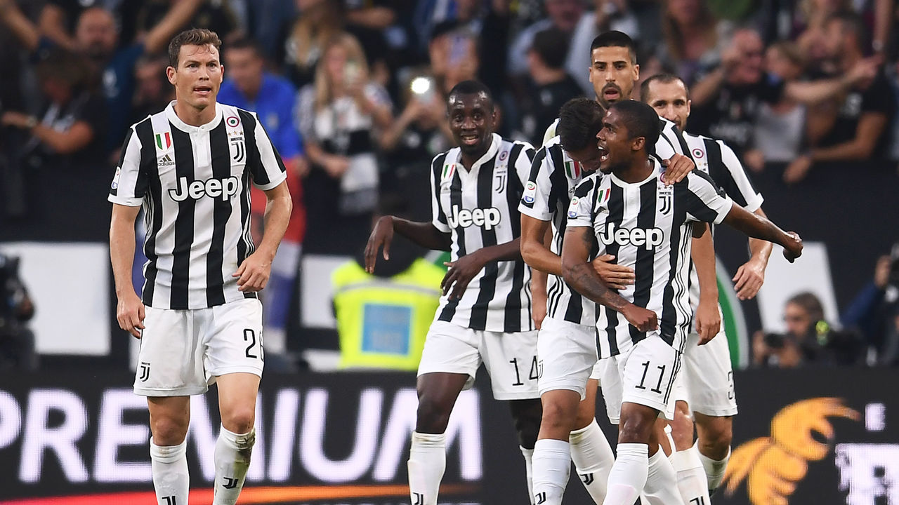 Juventus' midfielder Douglas Costa from Brazil (R) celebrates with teammates after scoring during the Italian Serie A football match Juventus Vs Lazio on October 14, 2017 at the 'Allianz Stadium' in Turin. / AFP PHOTO / MARCO BERTORELLO
