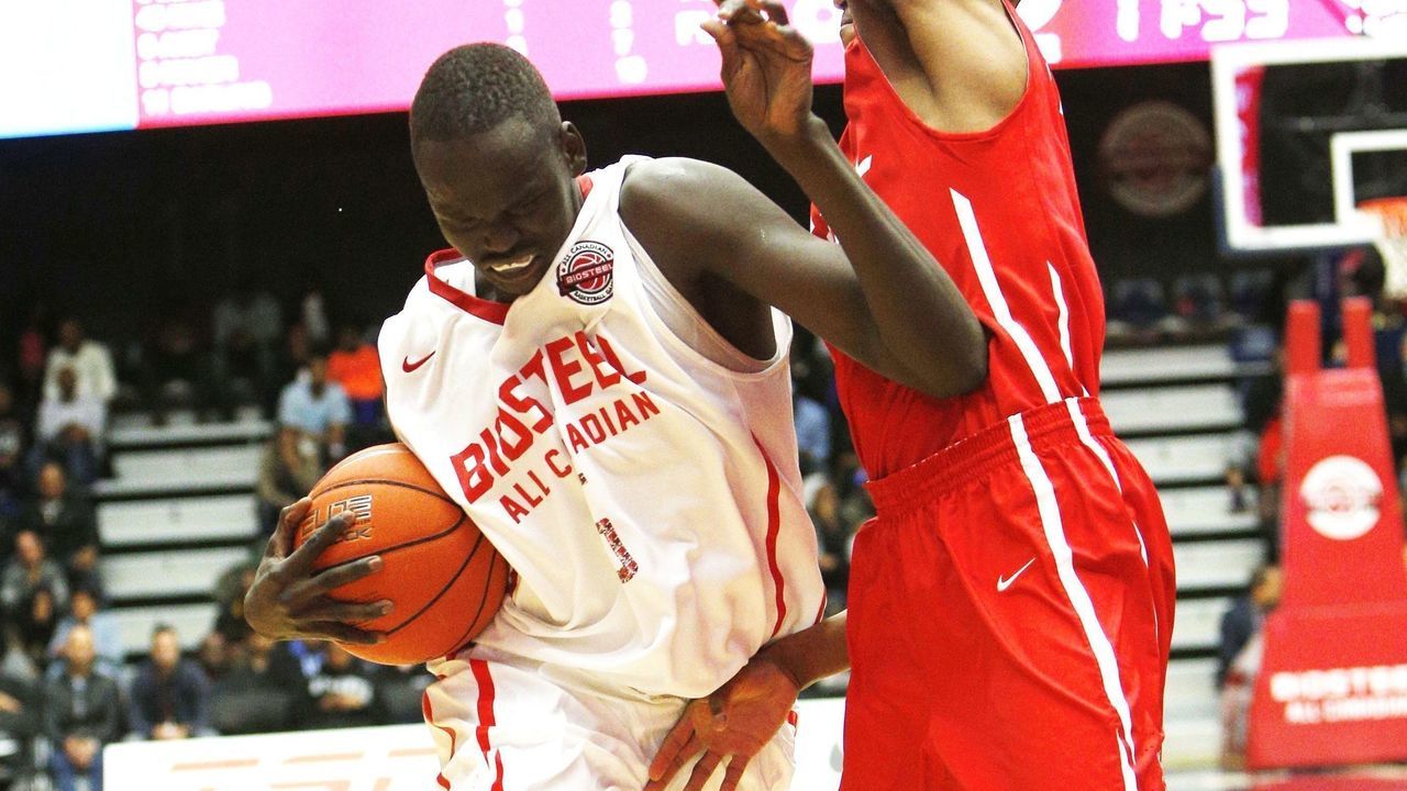 TORONTO, ON - APRIL 11 - Matur Maker of team white drives past O'Shae Brissett of team red during the second half of basketball action during the Biosteel All Canadian game. (Carlos Osorio/Toronto Star via Getty Images)