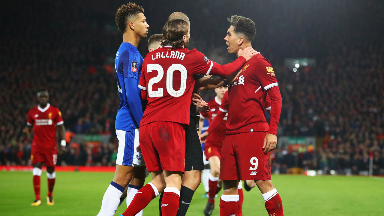 LIVERPOOL, ENGLAND - JANUARY 05: Referee Robert Madley and Adam Lallana of Liverpool intervene as Mason Holgate of Everton and Roberto Firmino of Liverpool clash during the Emirates FA Cup Third Round match between Liverpool and Everton at Anfield on January 5, 2018 in Liverpool, England.