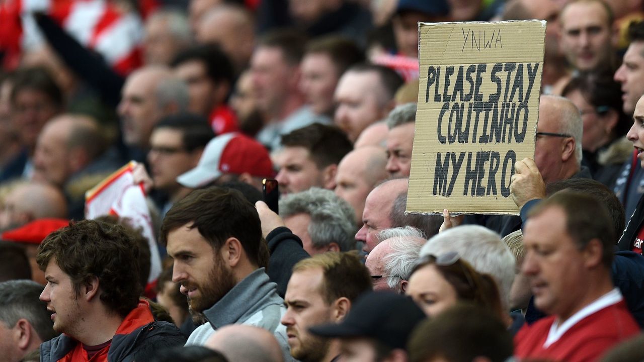 A fan holds up a placard in support of Liverpool's Brazilian midfielder Philippe Coutinho during the English Premier League football match between Liverpool and Crystal Palace at Anfield in Liverpool, north west England on August 19, 2017. / AFP PHOTO / Oli SCARFF /