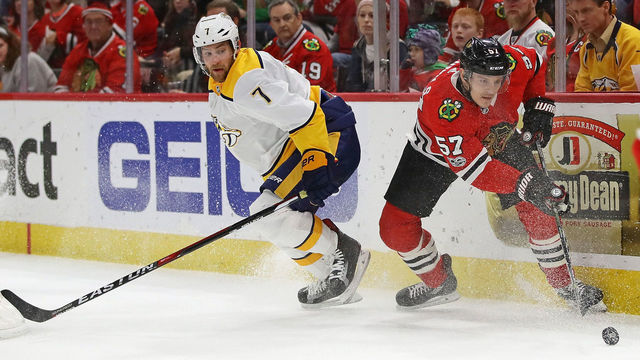 CHICAGO, IL - OCTOBER 27: Tommy Wingels #57 of the Chicago Blackhawks and Yannick Weber #7 of the Nashville Predators moves to the puck at the United Center on October 27, 2017 in Chicago, Illinois.