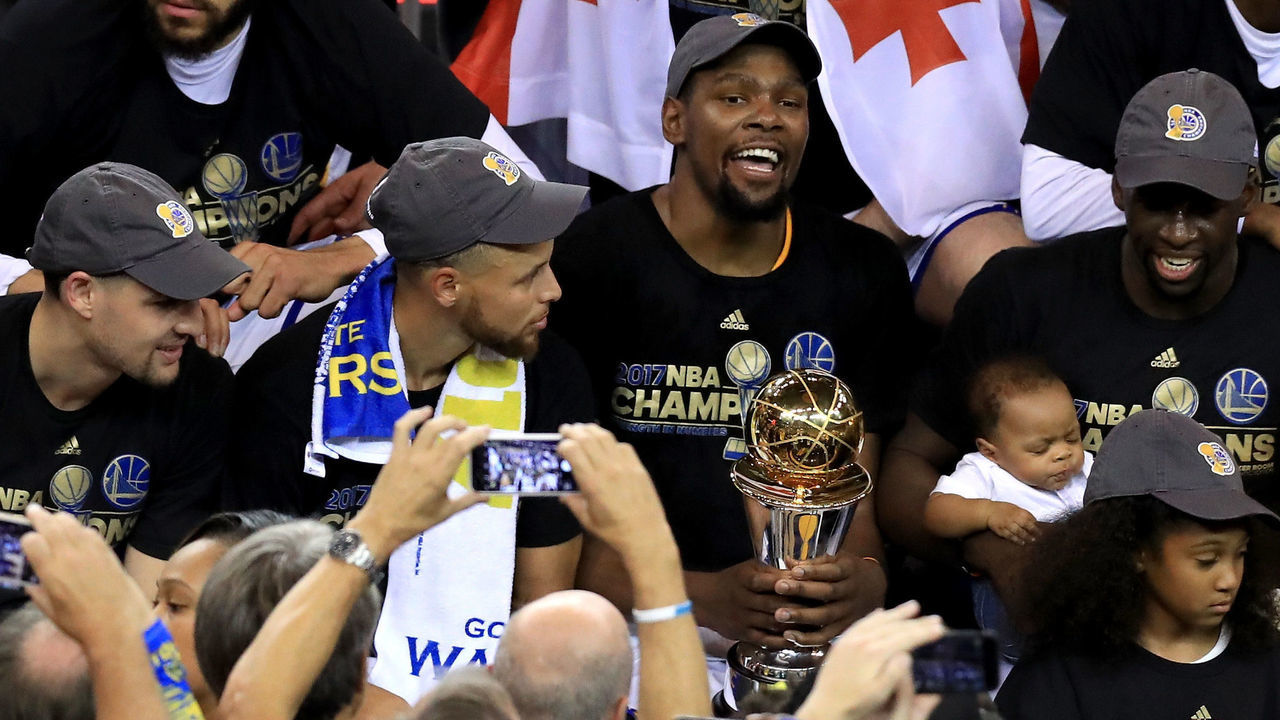 OAKLAND, CA - JUNE 12: Klay Thompson #11, JaVale McGee #1, Stephen Curry #30, Kevin Durant #35 with the Bill Russell NBA Finals Most Valuable Player Award and Draymond Green #23 of the Golden State Warriors celebrate after defeating the Cleveland Cavaliers 129-120 in Game 5 to win the 2017 NBA Finals at ORACLE Arena on June 12, 2017 in Oakland, California.