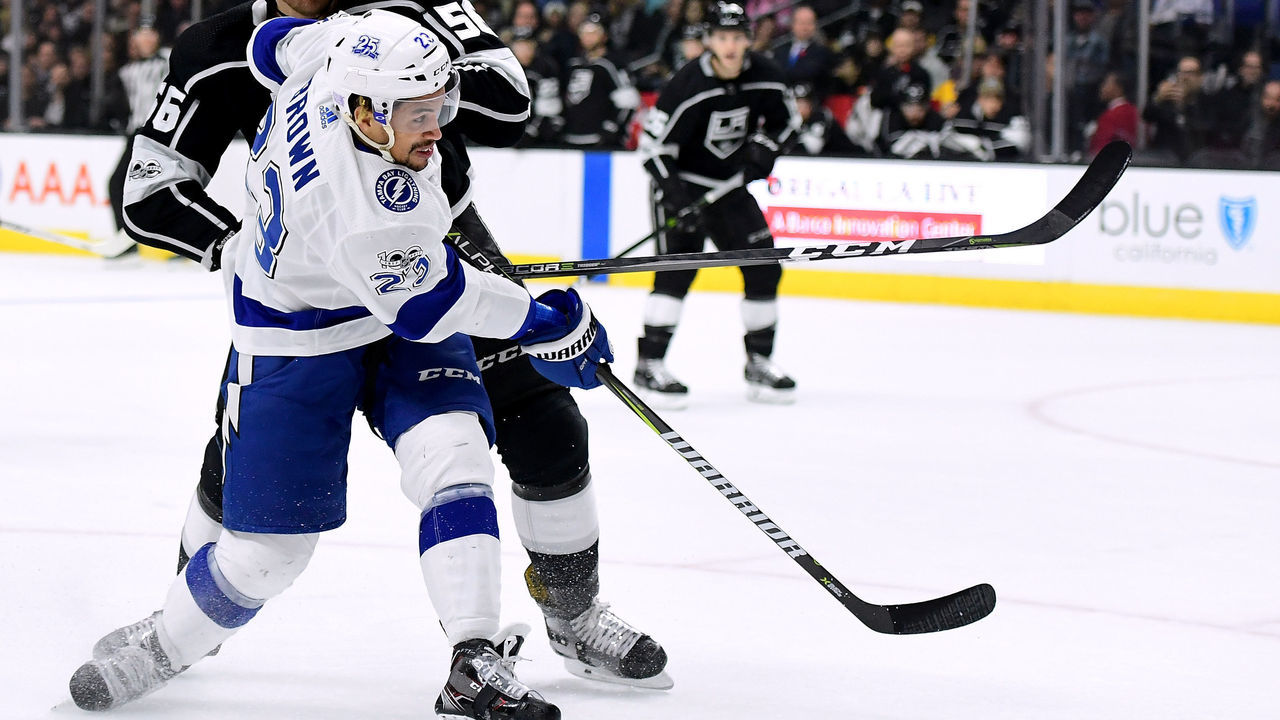 LOS ANGELES, CA - NOVEMBER 09: J.T. Brown #23 of the Tampa Bay Lightning attempts a shot as he is hit by Kurtis MacDermid #56 of the Los Angeles Kings during the first period at Staples Center on November 9, 2017 in Los Angeles, California.