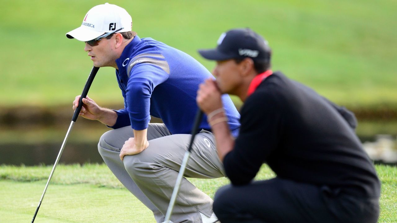 US golfers Tiger Woods (R) and Zach Johnson line up their putts on the green at the 18th hole during a playoff which Johnson won to win the Northwestern Mutual World Challenge golf tournament at the Sherwood Country Club in Thousand Oaks, California, on December 8, 2013. AFP PHOTO / Frederic J. Brown