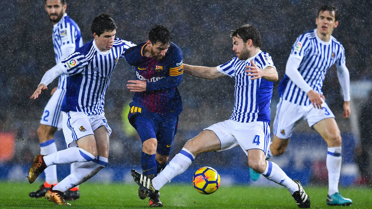 SAN SEBASTIAN, SPAIN - JANUARY 14: Lionel Messi of FC Barcelona competes for the ball withIgor Zubeldia (L) and Asier Illarramendi of Real Sociedad de Futbol during the La Liga match between Real Sociedad and FC Barcelona at Anoeta stadium on January 14, 2018 in San Sebastian, Spain.