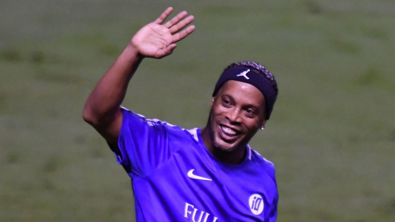 Brazilian football star Ronaldinho (R) of the Galacticos team celebrates at the Nacional stadium in San Jose, Costa Rica on August 5, 2017 during an exhibition match. / AFP PHOTO / Ezequiel Becerra