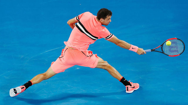 MELBOURNE, AUSTRALIA - JANUARY 17: Grigor Dimitrov of Bulgaria plays a backhand volley in his second round match against Mackenzie McDonald of the United States on day three of the 2018 Australian Open at Melbourne Park on January 17, 2018 in Melbourne, Australia.