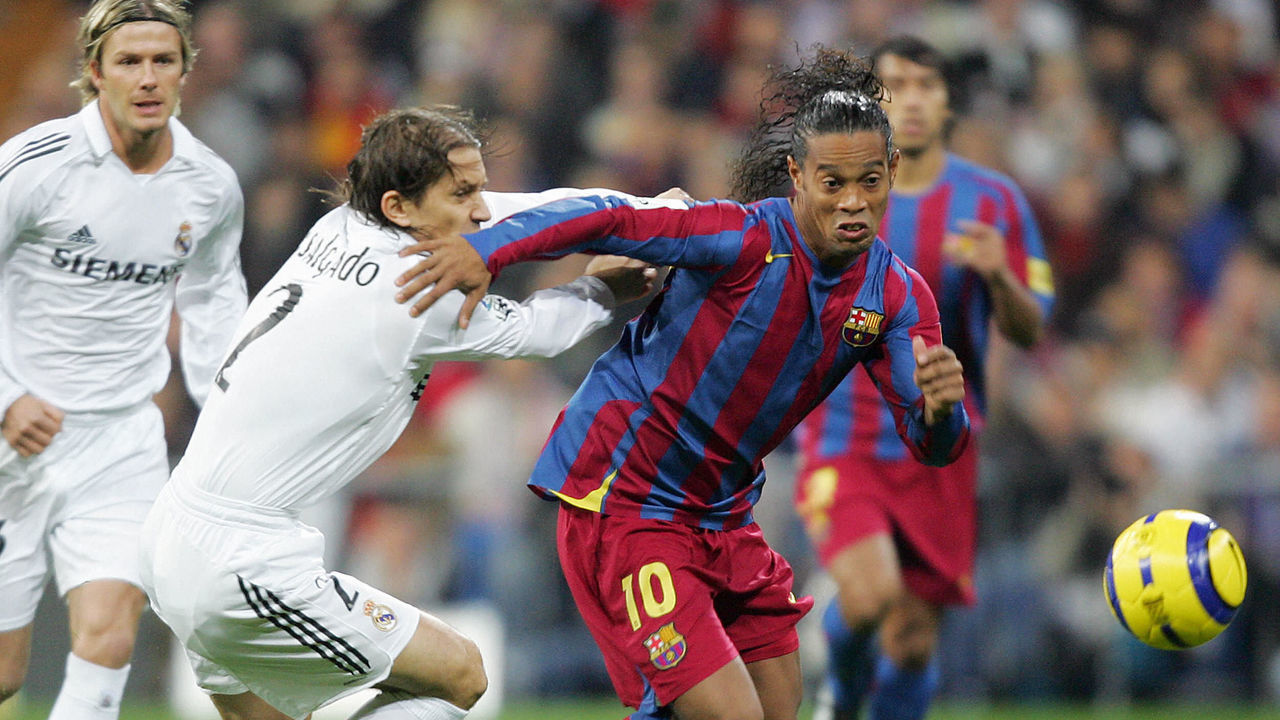 Madrid, SPAIN: Real Madrid's Michel Salgado (L) vies with Barcelona's Ronaldinho (R) during their Spanish League football match at Santiago Bernabeu stadium in Madrid, 19 November, 2005. AFP PHOTO JAVIER SORIANO