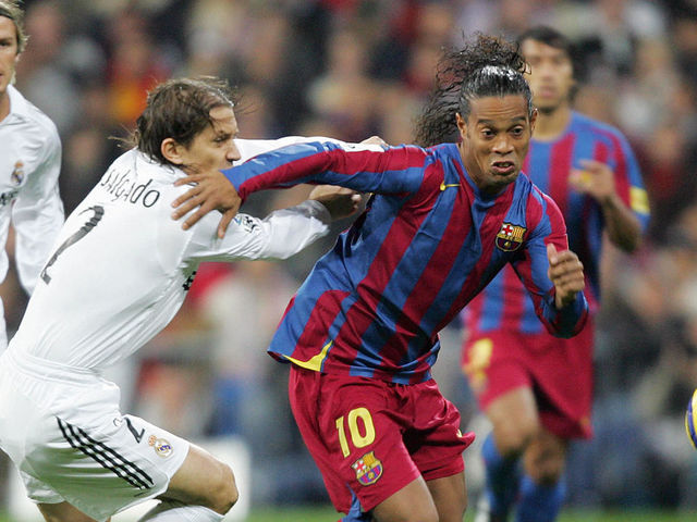 Madrid, SPAIN: Real Madrid's Michel Salgado (L) vies with Barcelona's Ronaldinho (R) during their Spanish League football match at Santiago Bernabeu stadium in Madrid, 19 November, 2005. AFP PHOTO JAVIER SORIANO