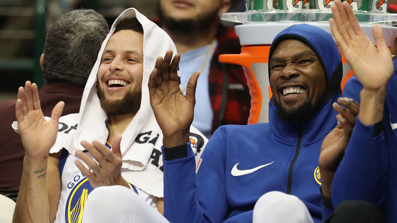 DALLAS, TX - JANUARY 03: (L-R) Stephen Curry #30 and Kevin Durant #35 of the Golden State Warriors share a laugh during play against the Dallas Mavericks at American Airlines Center on January 3, 2018 in Dallas, Texas.
