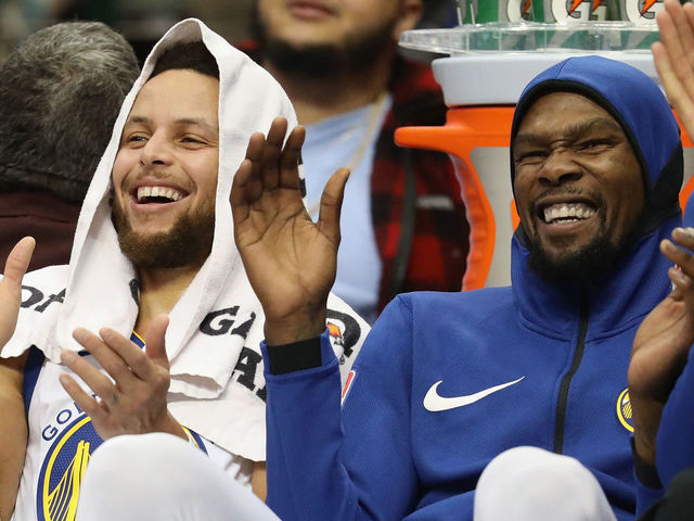 DALLAS, TX - JANUARY 03: (L-R) Stephen Curry #30 and Kevin Durant #35 of the Golden State Warriors share a laugh during play against the Dallas Mavericks at American Airlines Center on January 3, 2018 in Dallas, Texas.