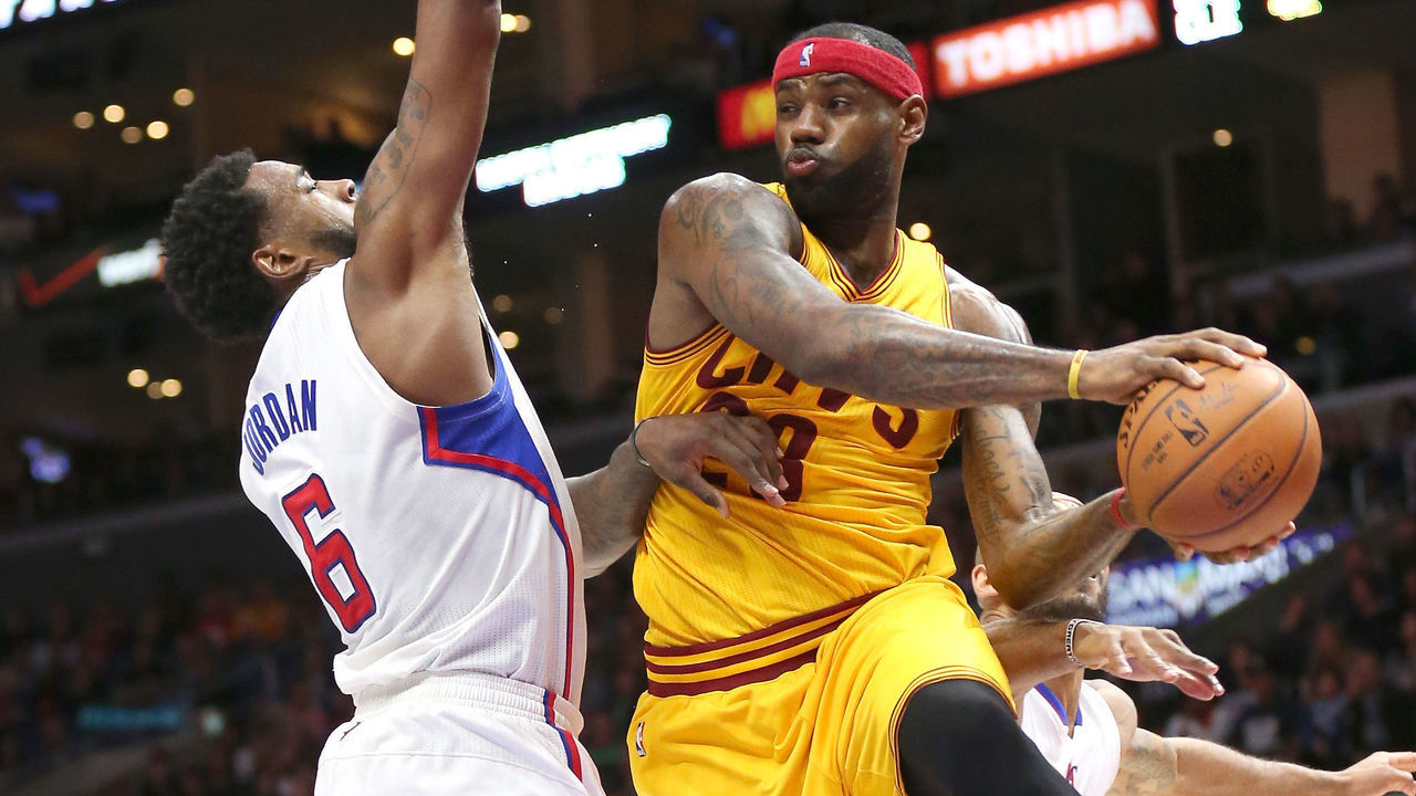 LOS ANGELES, CA - JANUARY 16: LeBron James #23 of the Cleveland Cavaliers jumps to throw a pass around DeAndre Jordan #6 of the Los Angeles Clippers at Staples Center on January 16, 2015 in Los Angeles, California. The Cavaliers won 126-121.