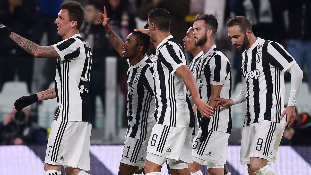 Juventus' Brazilian midfielder Douglas Costa (2-L) celebrates with teammates after scoring a goal during the Italian Serie A football match Juventus versus Genoa on January 22, 2018 at the 'Allianz Stadium' in Turin. / AFP PHOTO / MARCO BERTORELLO