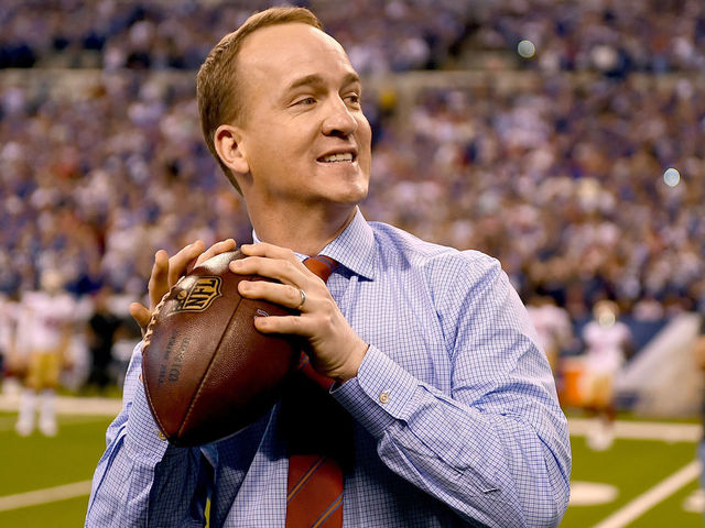 INDIANAPOLIS, IN - OCTOBER 08: Peyton Manning steps back to throw a pass to former teammate Marvin Harrison during a presentation to retire Manning's number during the halftime of the game between the Indianapolis Colts and the San Francisco 49ers at Lucas Oil Stadium on October 8, 2017 in Indianapolis, Indiana.