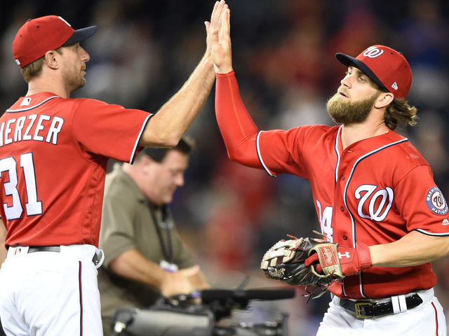 WASHINGTON, DC - JULY 30: Bryce Harper #34 of the Washington Nationals celebrates a win with Max Scherzer #31 after game two of a doubleheader against the Colorado Rockies at Nationals Park on July 30, 2017 in Washington, DC.