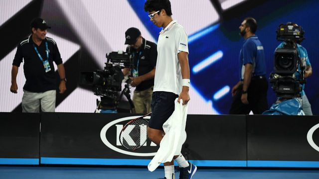 South Korea's Chung Hyeon walks on court during his men's singles semi-finals match against Switzerland's Roger Federer on day 12 of the Australian Open tennis tournament in Melbourne on January 26, 2018. Defending champion Roger Federer strolled into the Australian Open final in a bitter-sweet win after Chung Hyeon's retired injured in their semi-final. The Swiss star was leading 6-1, 5-2 when the South Korean called it quits with foot blisters and will now face Marin Cilic in Sunday's final. / AFP PHOTO / WILLIAM WEST / -- IMAGE RESTRICTED TO EDITORIAL USE - STRICTLY NO COMMERCIAL USE --