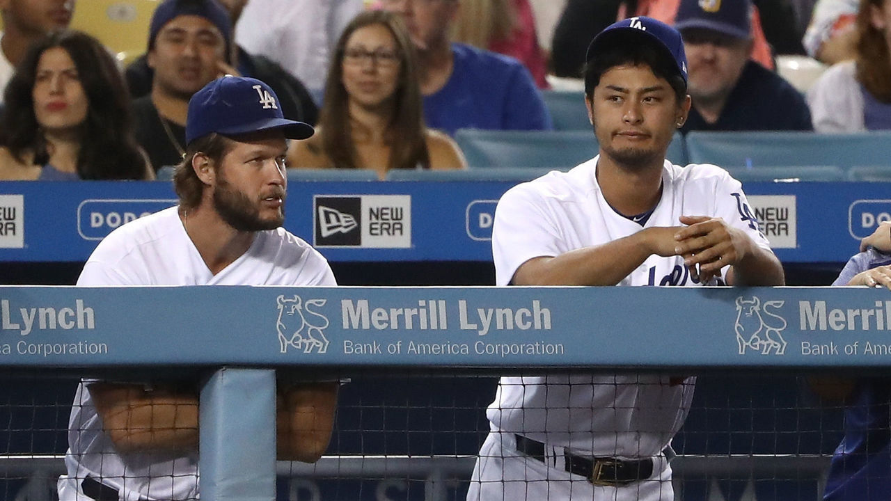 LOS ANGELES, CA - AUGUST 11: (L-R) Alex Wood #57, Clayton Kershaw #22 and Yu Darvish #21 of the Los Angeles Dodgers look on from the dugout with the Dodgers down 4-3 to the San Diego Padres during the ninth inning of their MLB game at Dodger Stadium on August 11, 2017 in Los Angeles, California. The Padres defeated the Dodgers 4-3.