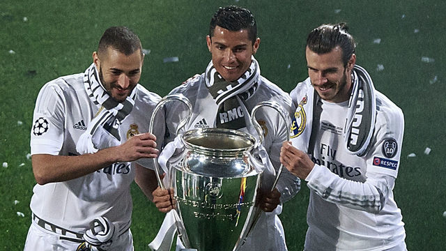 MADRID, SPAIN - MAY 29: Cristiano Ronaldo (2ndL) of Real Madrid CF holds the trophy as he poses for a picture with his teammates Karim Benzema (L) and Gareth Bale (R) during the celebration with their fans at Santiago Bernabeu Stadium the day after winning the UEFA Champions League Final match against Club Atletico de Madrid on May 29, 2016 in Madrid, Spain. Real Madrid CF is the only European football team with 11 European Cups