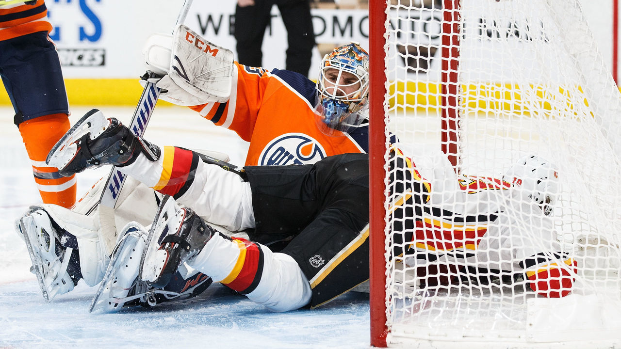 EDMONTON, AB - JANUARY 25: Goaltender Cam Talbot #33 of the Edmonton Oilers sits underneath Matthew Tkachuk #19 of the Calgary Flames at Rogers Place on January 25, 2018 in Edmonton, Canada.