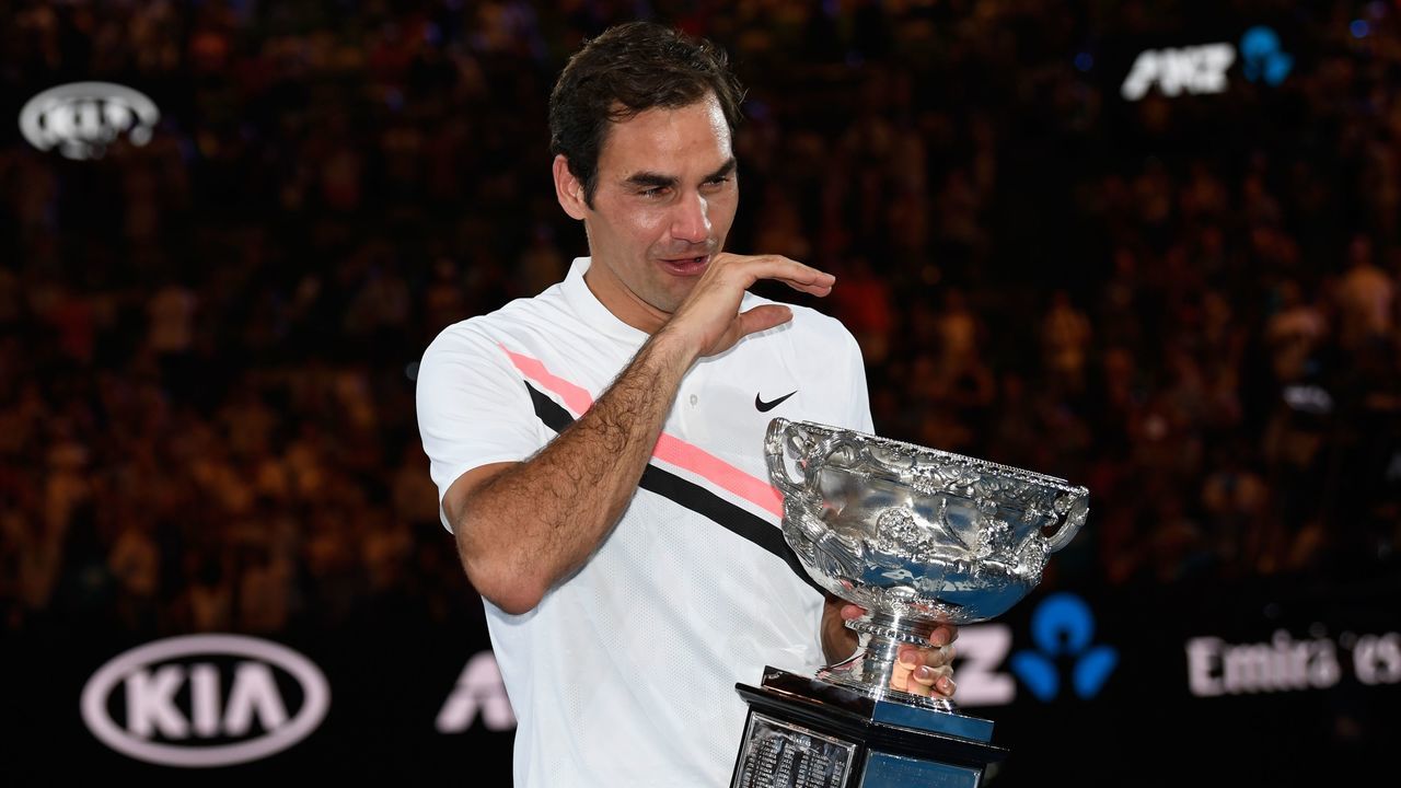 Switzerland's Roger Federer cries as he holds the winner's trophy after beating Croatia's Marin Cilic in their men's singles final match on day 14 of the Australian Open tennis tournament in Melbourne on January 28, 2018. / AFP PHOTO / SAEED KHAN / -- IMAGE RESTRICTED TO EDITORIAL USE - STRICTLY NO COMMERCIAL USE --