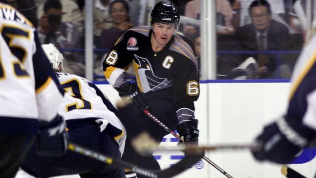 YONO, JAPAN: Jaromir Jagr (C) of the Pittsburgh Penguins keeps the puck during the National Hockey League (NHL) regular season match against the Nashville Predators at the new Saitama Super Arena in Yono, in suburban Tokyo, 08 October 2000. The Penguins beat the Predators 3-1. AFP PHOTO/Kazihiro NOGI