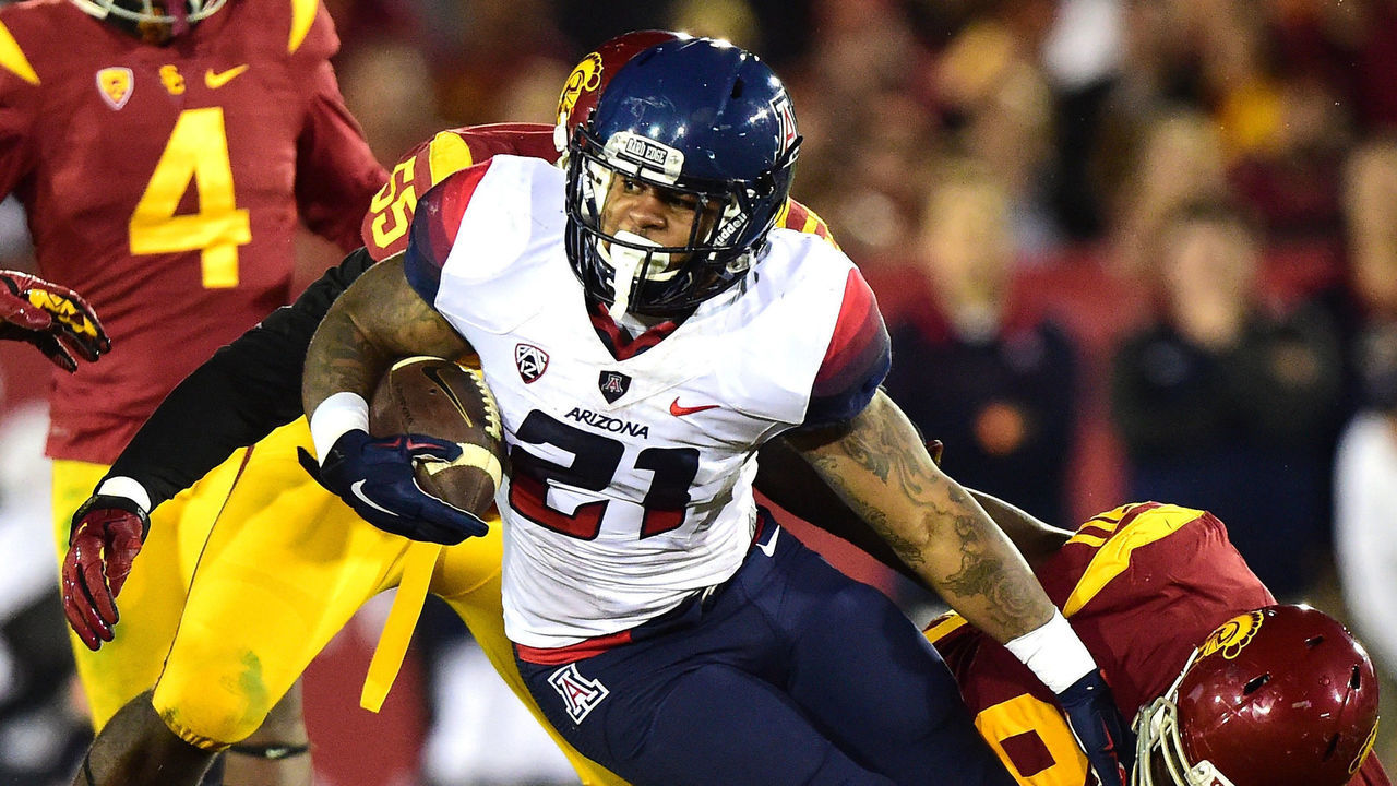 LOS ANGELES, CA - NOVEMBER 07: Orlando Bradford #21 of the Arizona Wildcats is stopped by Claude Pelon #90 of the USC Trojans on third down during the third quarter at Los Angeles Coliseum on November 7, 2015 in Los Angeles, California.