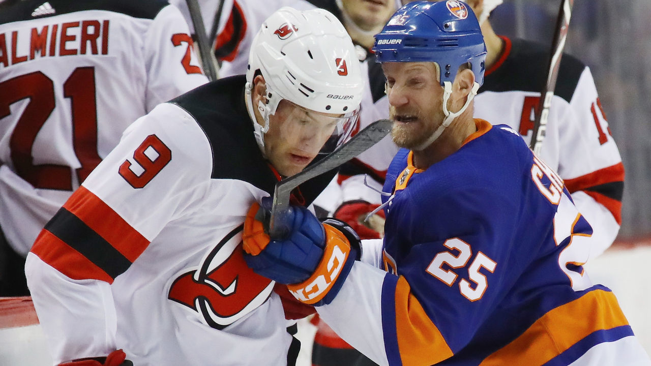 NEW YORK, NY - JANUARY 07: Taylor Hall #9 of the New Jersey Devils is held up by Jason Chimera #25 of the New York Islanders during the first period at the Barclays Center on January 7, 2018 in the Brooklyn borough of New York City.