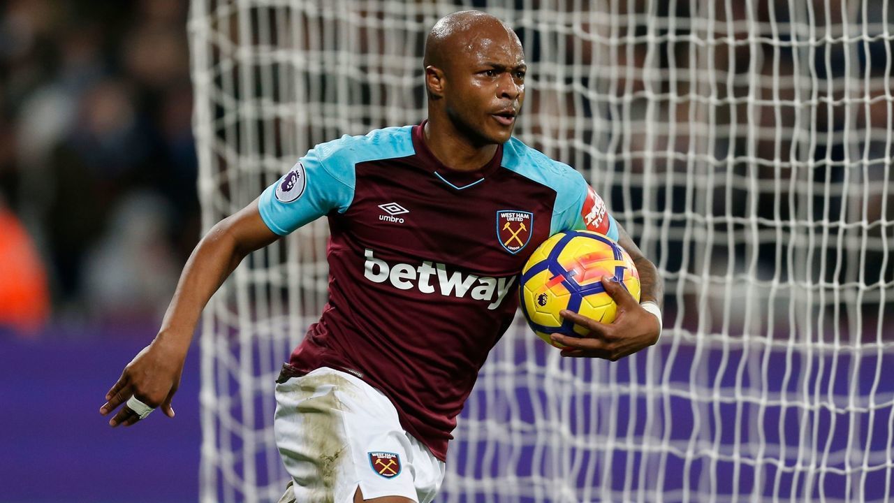 West Ham United's French-born Ghanaian midfielder Andre Ayew collects the ball as he celebrates after scoring their second goal during the English Premier League football match between West Ham United and Newcastle United at The London Stadium, in east London on December 23, 2017. / AFP PHOTO / Ian KINGTON /