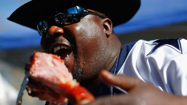 ARLINGTON, TX - NOVEMBER 27: Dallas Cowboys fan Gary Smiley enjoys a turkey leg before the Philadelphia Eagles take on the Dallas Cowboys at AT&T Stadium on November 27, 2014 in Arlington, Texas.
