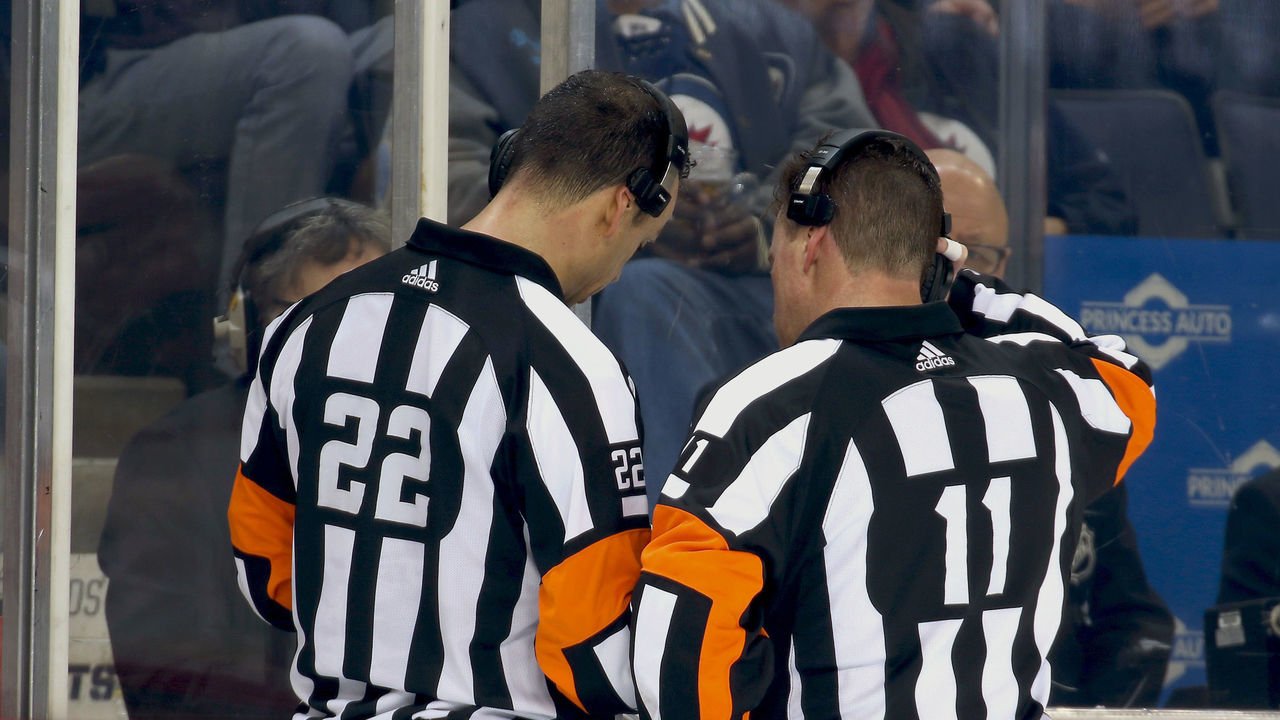 WINNIPEG, MB - FEBRUARY 1: Referees Ghislain Hebert #22 and Kelly Sutherland #11 review a Vegas Golden Knights goal on a Coaches Challenge for Goaltender Interference during second period action against the Winnipeg Jets at the Bell MTS Place on February 1, 2018 in Winnipeg, Manitoba, Canada. Upon further review, the goal was deemed a good goal.