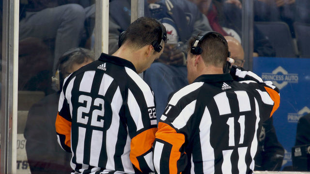 WINNIPEG, MB - FEBRUARY 1: Referees Ghislain Hebert #22 and Kelly Sutherland #11 review a Vegas Golden Knights goal on a Coaches Challenge for Goaltender Interference during second period action against the Winnipeg Jets at the Bell MTS Place on February 1, 2018 in Winnipeg, Manitoba, Canada. Upon further review, the goal was deemed a good goal.