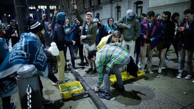 PHILADELPHIA, PA - FEBRUARY 04: People break a traffic light while celebrating the Philadelphia Eagles' victory in Super Bowl LII game against the New England Patriots on February 4, 2018 in Philadelphia, Pennsylvania..